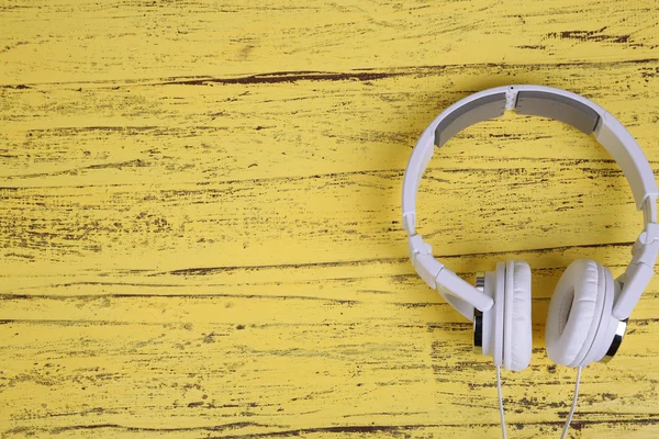 White headphones on wooden table close-up — Stock Photo, Image