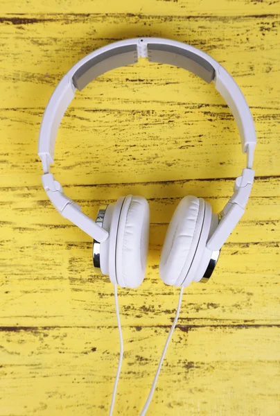 White headphones on wooden table close-up — Stock Photo, Image
