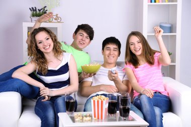 Grup genç arkadaşlar evde televizyon izlerken