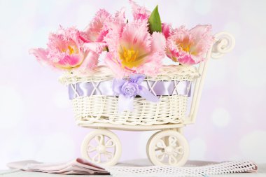 açık renkli ahşap masaya üzerinde dekoratif sepet içinde güzel laleler