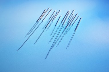 için mavi arka plan üzerinde akupunktur iğneleri