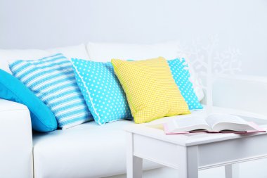 Beyaz kanepe ile oda içinde renkli yastıklar 