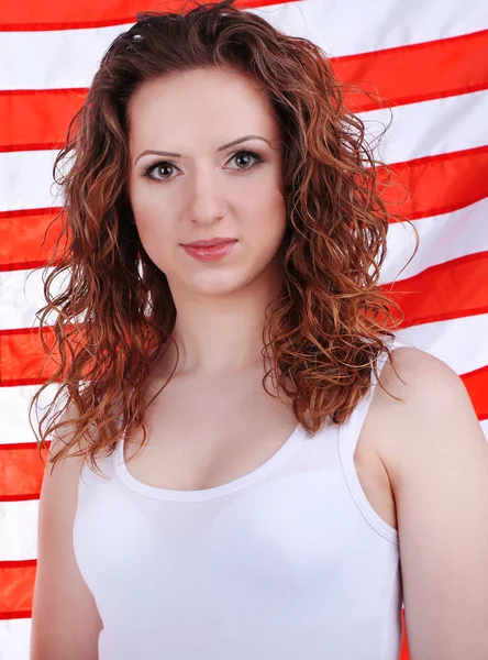 Beautiful young women on background of American flag — Stock Photo, Image