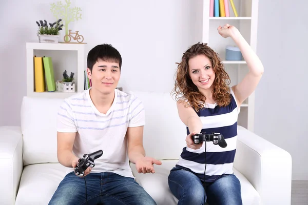 Menina e menino jogando jogos de vídeo em casa — Fotografia de Stock