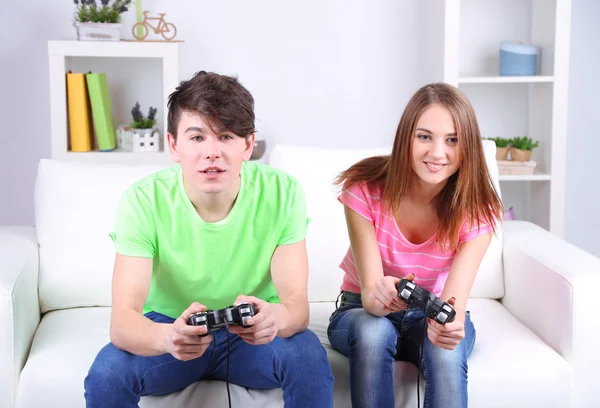 Menina e menino jogando jogos de vídeo em casa — Fotografia de Stock