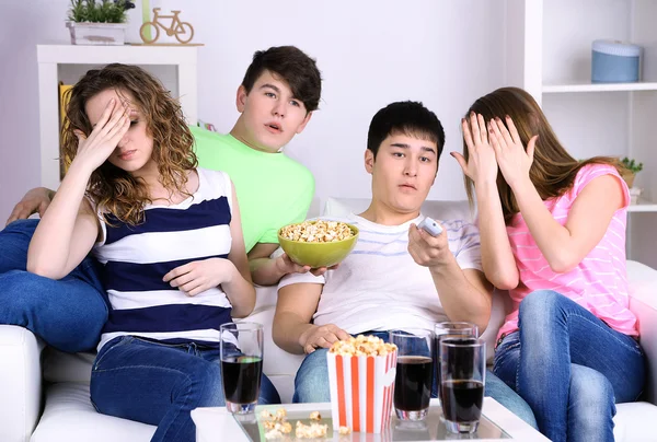 Grupo de jóvenes amigos viendo la televisión en casa — Foto de Stock