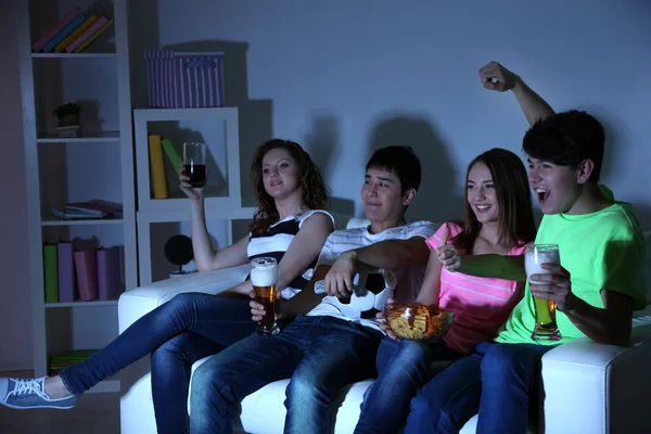 Grupo de jóvenes amigos viendo la televisión en casa de apagón — Foto de Stock