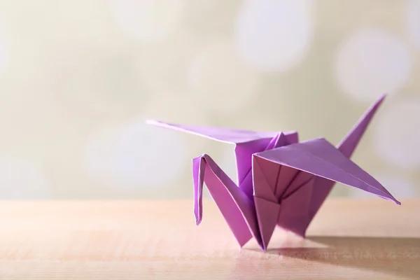 Γερανός origami στο ξύλινο τραπέζι, επάνω ελαφρύς υπόβαθρο — Φωτογραφία Αρχείου