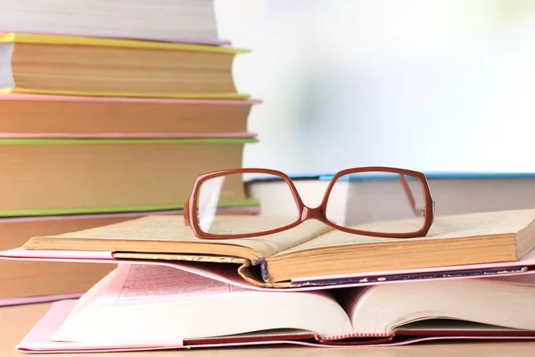 Samenstelling met glazen en boeken, op tafel, op lichte achtergrond — Stockfoto