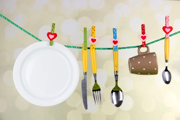 Tableware dried on rope on bright background — Stock Photo, Image