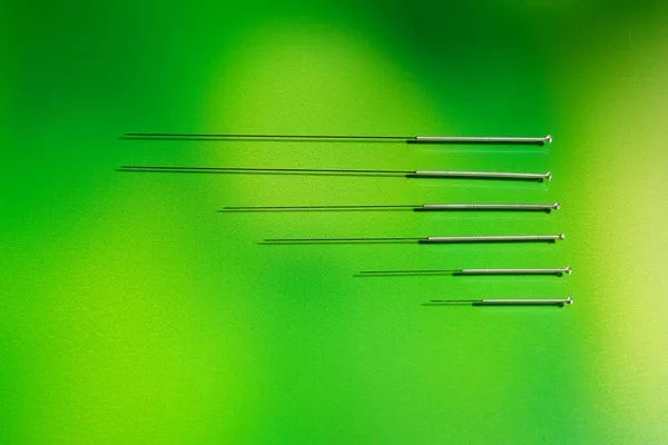 Aiguilles pour acupuncture sur fond vert — Photo