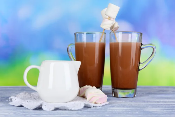 Warme chocolademelk met marshmallows, op blauwe achtergrond — Stockfoto