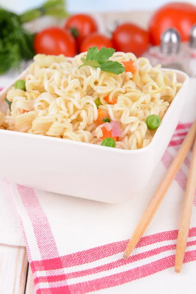 Tasty instant noodles with vegetables in bowl on table close-up — Stock Photo, Image