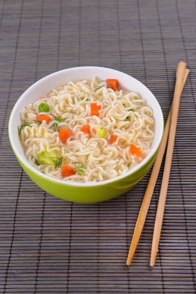 Sabrosos fideos instantáneos con verduras en un tazón en la mesa de cerca — Foto de Stock