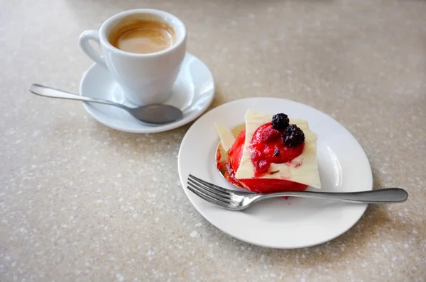 Torta gustosa con bacche e tazza di caffè sul tavolo nel caffè — Foto Stock