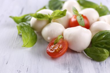 ahşap masa üstünde domates ve fesleğen ile lezzetli mozzarella peyniri
