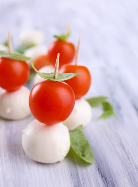 ahşap masa üstünde domates ve fesleğen ile lezzetli mozzarella peyniri