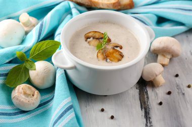 peçeteye ahşap arka plan üzerinde beyaz tencerede mantar çorbası