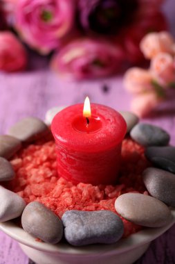 spa taşlar, mum ve ışık arka plan üzerinde renkli ahşap masaya çiçek kompozisyonu