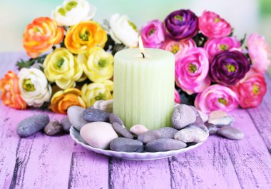 spa taşlar, mum ve ışık arka plan üzerinde renkli ahşap masaya çiçek kompozisyonu
