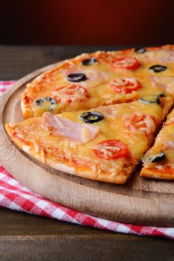 tablodaki koyu kırmızı zemin üzerine lezzetli pizza