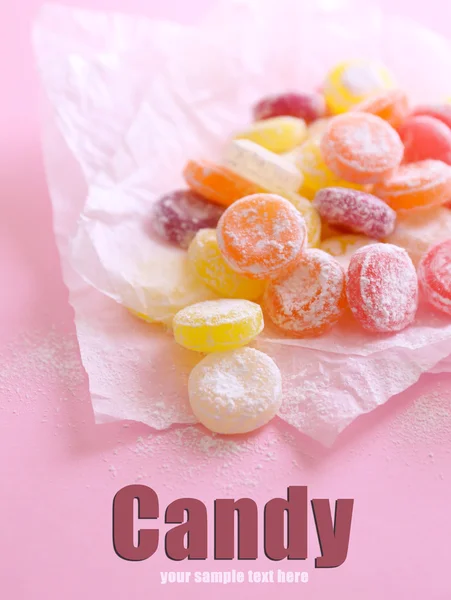 Sweet candies on paper, on color background — Stock Photo, Image