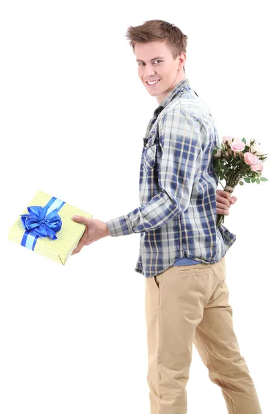 Jovem bonito com flores e presente, isolado em branco — Fotografia de Stock