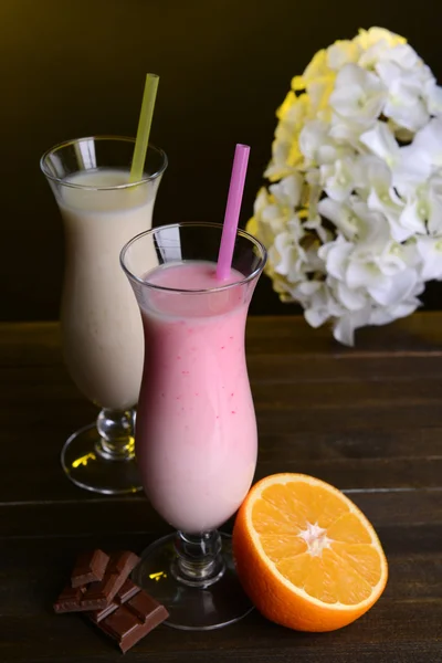 Melk schudt op tafel op donkere gele achtergrond — Stockfoto