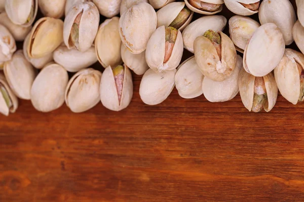 Pistachio nuts on wooden background — Stock Photo, Image