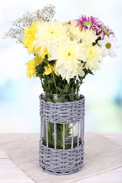 Vackra chrysanthemum blommor i vas på bordet på ljus bakgrund — Stockfoto