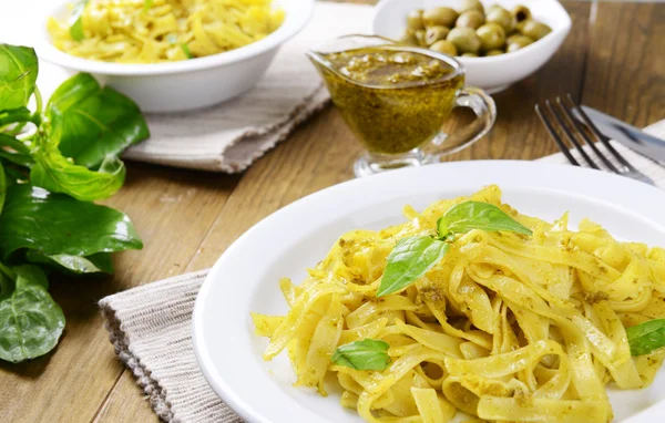 Delicious pasta with pesto on plate on table close-up — Stock Photo, Image