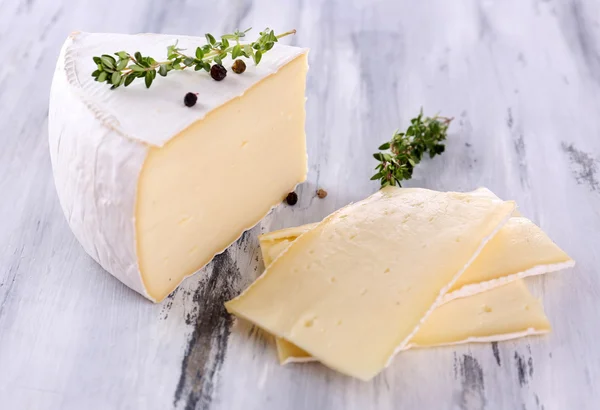 Välsmakande camembert ost med kryddor, på träbord — Stockfoto