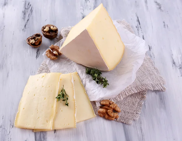 Queijo saboroso Camembert com nozes, sobre mesa de madeira — Fotografia de Stock