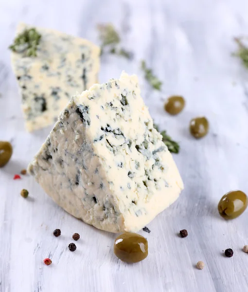 Smakelijke blauwe kaas met olijven op houten tafel — Stockfoto