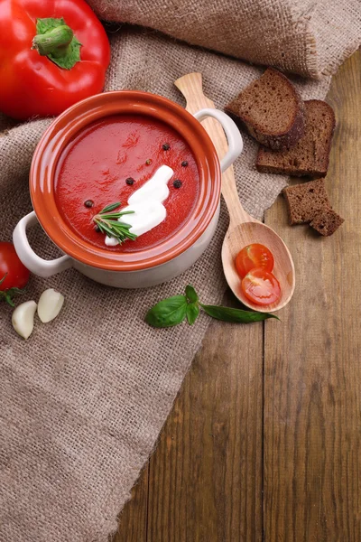 Smakelijke tomatensoep en groenten op houten tafel — Stockfoto