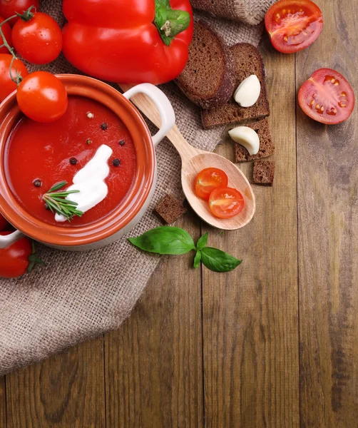 Soupe de tomates et légumes savoureux sur table en bois — Photo