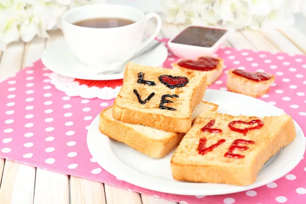 Delicioso brindis con mermelada y taza de té en primer plano de la mesa — Foto de Stock