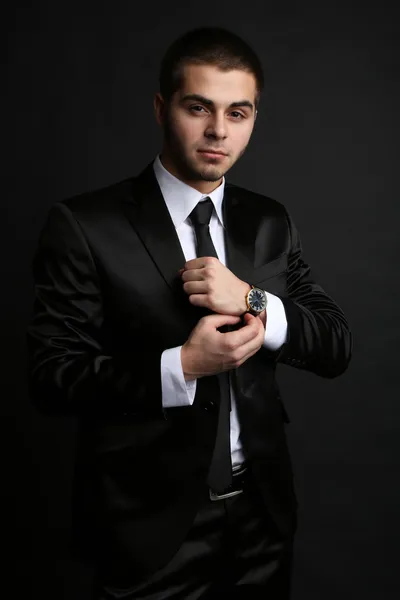 Όμορφος νεαρός άνδρας στο κοστούμι σε σκούρο φόντο — Φωτογραφία Αρχείου