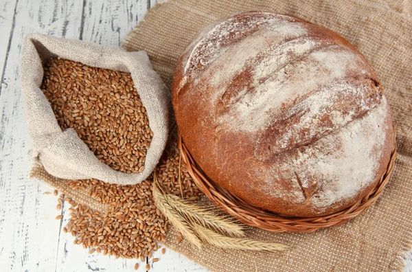 Pão de centeio com grãos em pano de saco na mesa de perto — Fotografia de Stock