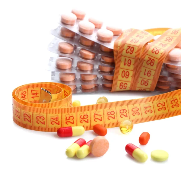 Measuring tape and pills, isolated on white. Dieting concept — Stock Photo, Image