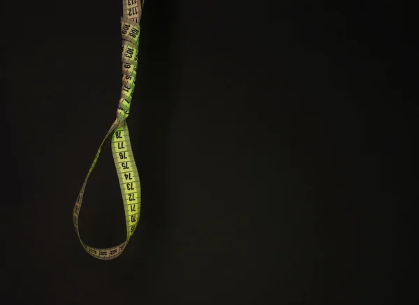 Tape measure noose on dark background - diet concept — Stock Photo, Image