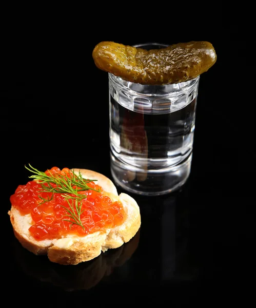 Vetro di vodka, caviale rosso e cetriolo isolato su nero — Foto Stock