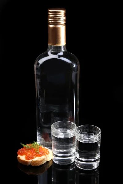 Склянка горілки, червона ікра ізольовані на чорному — стокове фото