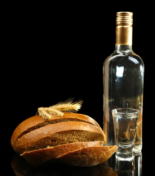Бутылка водки, свежий хлеб и стаканы изолированы на черном — стоковое фото