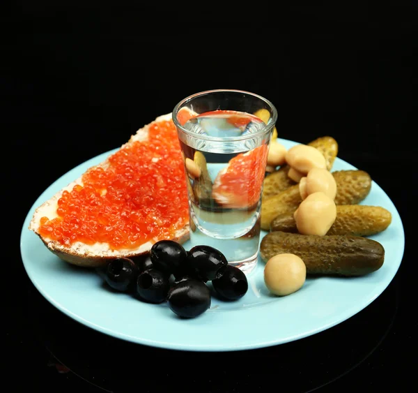 Composition with glass of vodka and snacks on color plate, isolated on black — Stock Photo, Image
