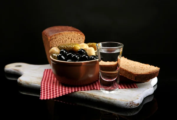 Composizione con bicchieri di vodka e verdure marinate, pane fresco su tavola di legno, isolato su nero — Foto Stock