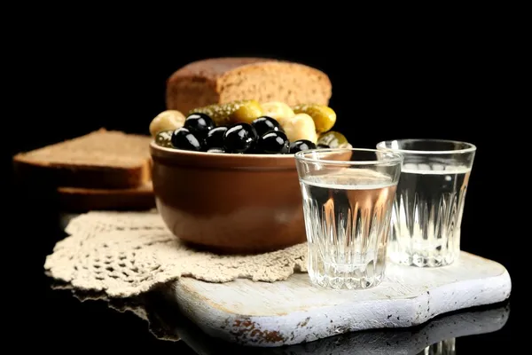 Composizione con bicchieri di vodka e verdure marinate, pane fresco su tavola di legno, isolato su nero — Foto Stock