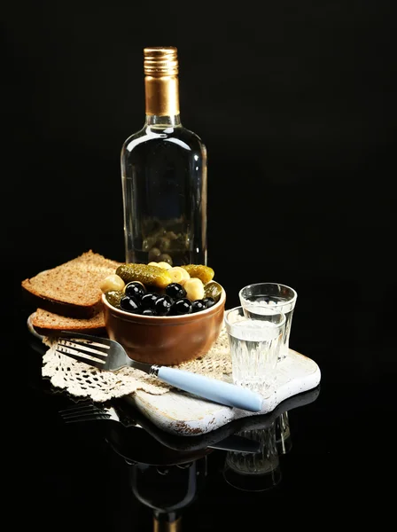 Composition avec bouteille de vodka et légumes marinés, pain frais sur planche de bois, isolé sur du noir — Photo