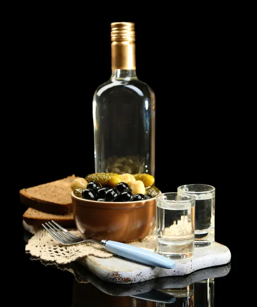 Komposition mit einer Flasche Wodka und mariniertem Gemüse, frischem Brot auf Holzbrett, isoliert auf schwarz — Stockfoto