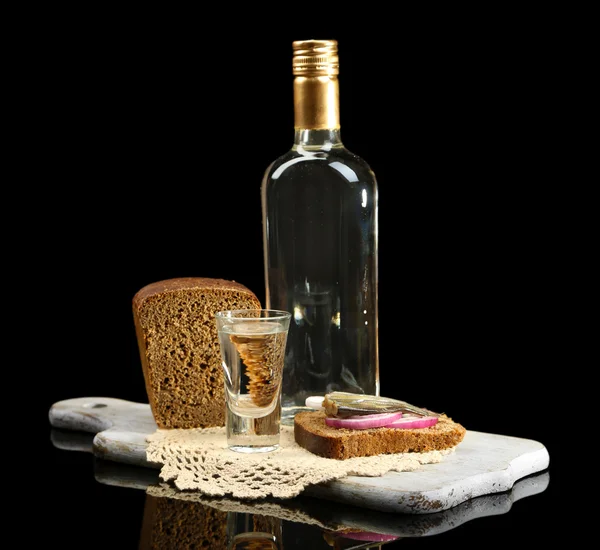Botella de vodka, sándwich con pescado salado y vasos sobre tabla de madera, aislado sobre negro — Foto de Stock